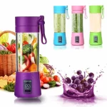 4 mini portable juicer blender in 4 different colors in front of a basket of fruit